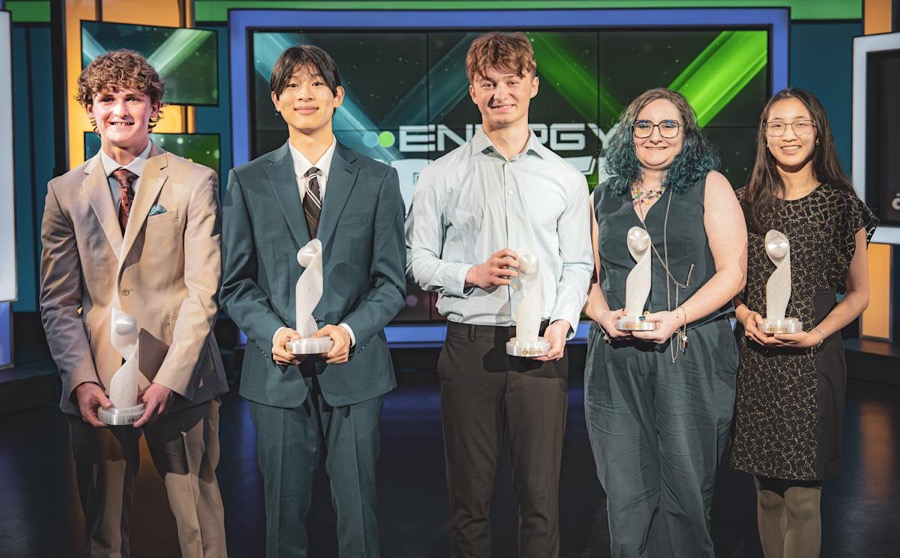 Five Energy Creates scholarship winners holding their trophies on set.